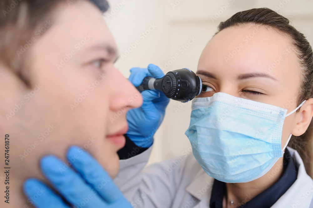 close up photo of a optometrist examining man's eyes with ophthalmoscope close up photo of a optometrist examining man's eyes with ophthalmoscope