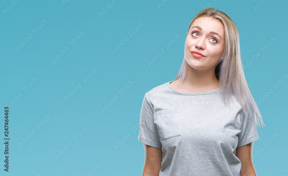 Obraz premium Young blonde woman over isolated background smiling looking side and staring away thinking.