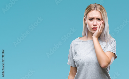 Young blonde woman over isolated background touching mouth with hand with painful expression because of toothache or dental illness on teeth. Dentist concept.