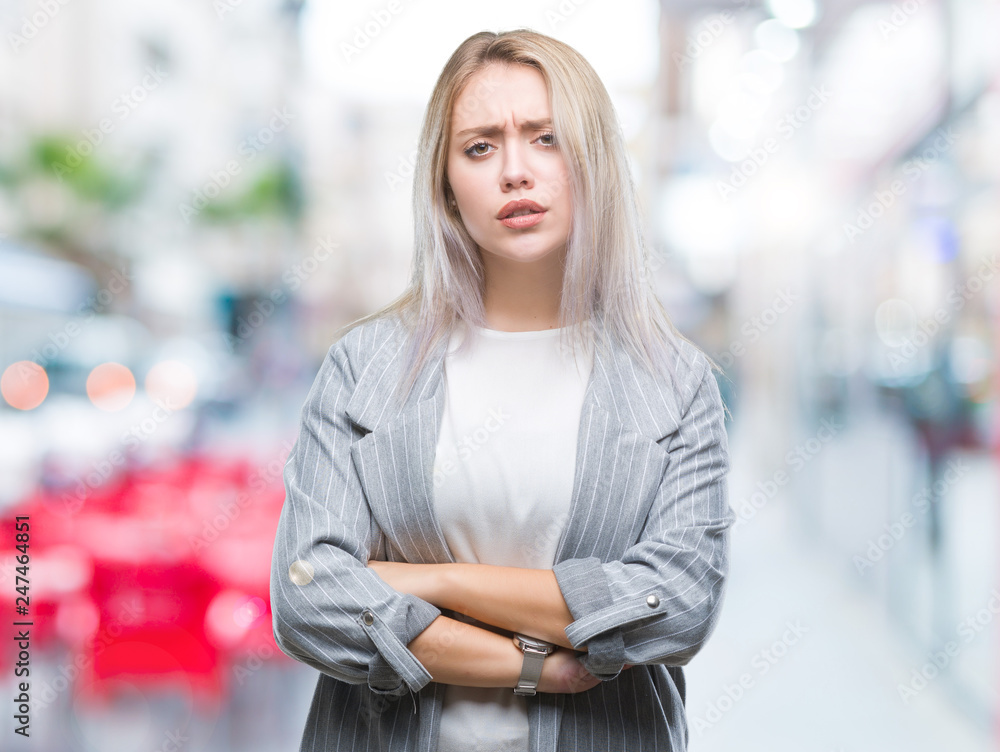 Young blonde business woman wearing jacket over isolated background skeptic and nervous, disapproving expression on face with crossed arms. Negative person. Young blonde business woman wearing jacket over isolated background skeptic and nervous, disapproving expression on face with crossed arms. Negative person.