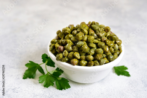 Schilderij op canvas Marinated capers in a white bowl.