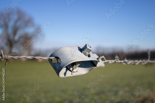 Tensioner for barbed wire at a meadow in winter photo