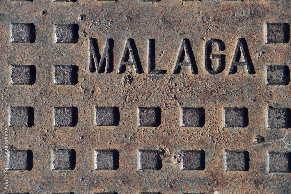 The cover of the well with the Malaga sign. - obrazy, fototapety, plakaty 
