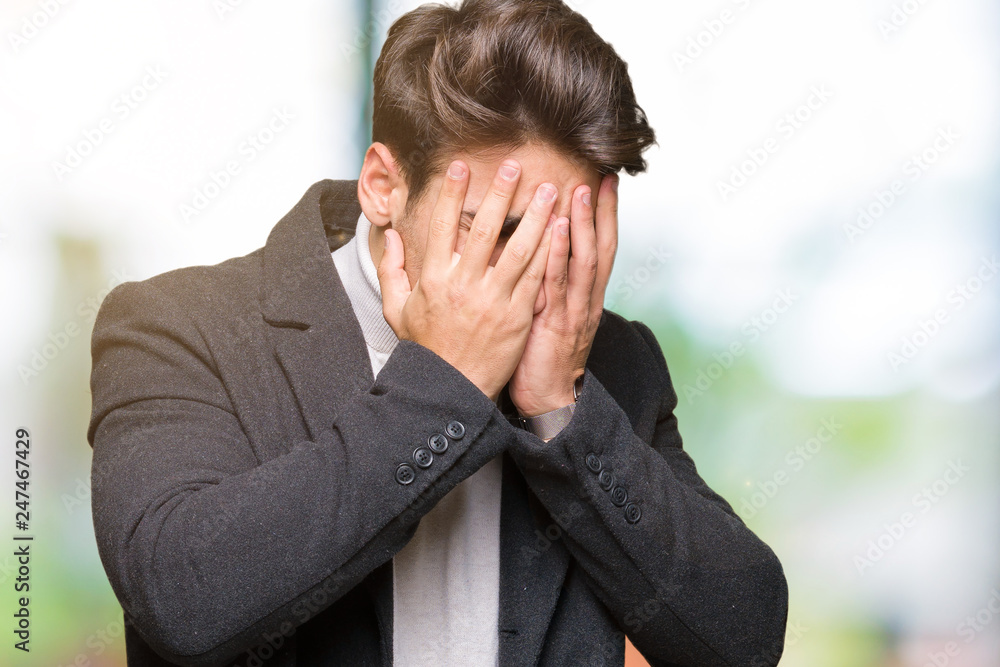 Young elegant man wearing winter coat over isolated background with sad expression covering face with hands while crying. Depression concept. Young elegant man wearing winter coat over isolated background with sad expression covering face with hands while crying. Depression concept.