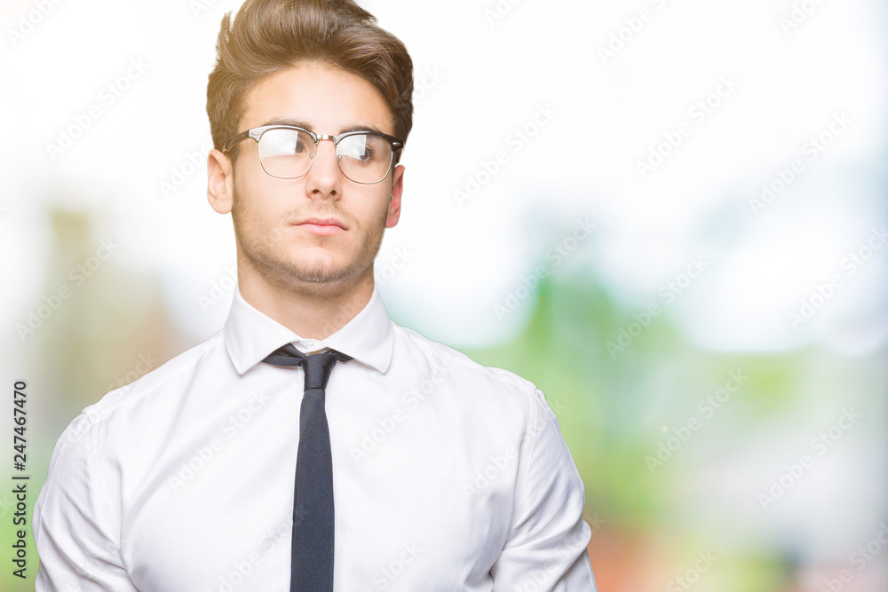 Young business man wearing glasses over isolated background smiling looking side and staring away thinking. Young business man wearing glasses over isolated background smiling looking side and staring away thinking.