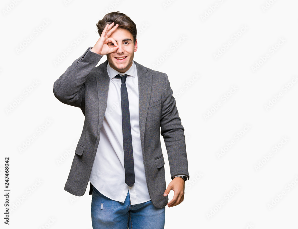 Young business man wearing suit and tie over isolated background doing ok gesture with hand smiling, eye looking through fingers with happy face. Young business man wearing suit and tie over isolated background doing ok gesture with hand smiling, eye looking through fingers with happy face.