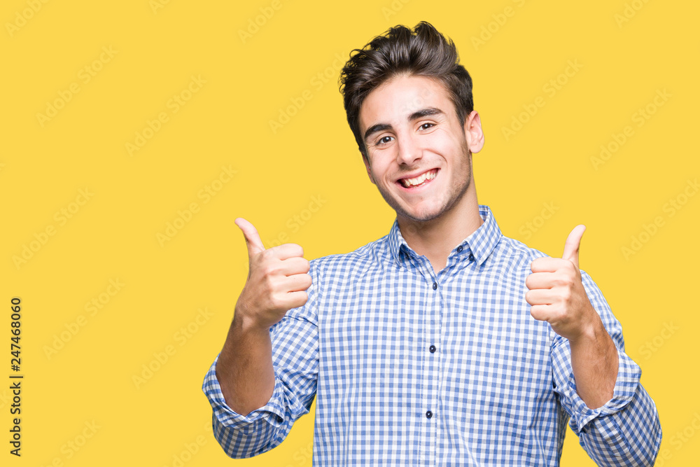 Young handsome business man over isolated background success sign doing positive gesture with hand, thumbs up smiling and happy. Looking at the camera with cheerful expression, winner gesture. Young handsome business man over isolated background success sign doing positive gesture with hand, thumbs up smiling and happy. Looking at the camera with cheerful expression, winner gesture.