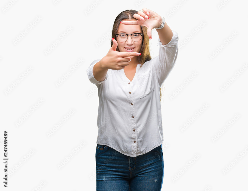 Fototapeta premium Young caucasian beautiful business woman wearing glasses over isolated background smiling making frame with hands and fingers with happy face. Creativity and photography concept.