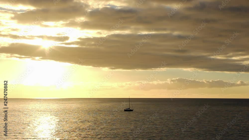 Silhouette of sailboat on vast sea at splendid sunset. Lonely ship at twilight with sunlight reflection on ocean. Lost, travel, paradise concepts Silhouette of sailboat on vast sea at splendid sunset. Lonely ship at twilight with sunlight reflection on ocean. Lost, travel, paradise concepts