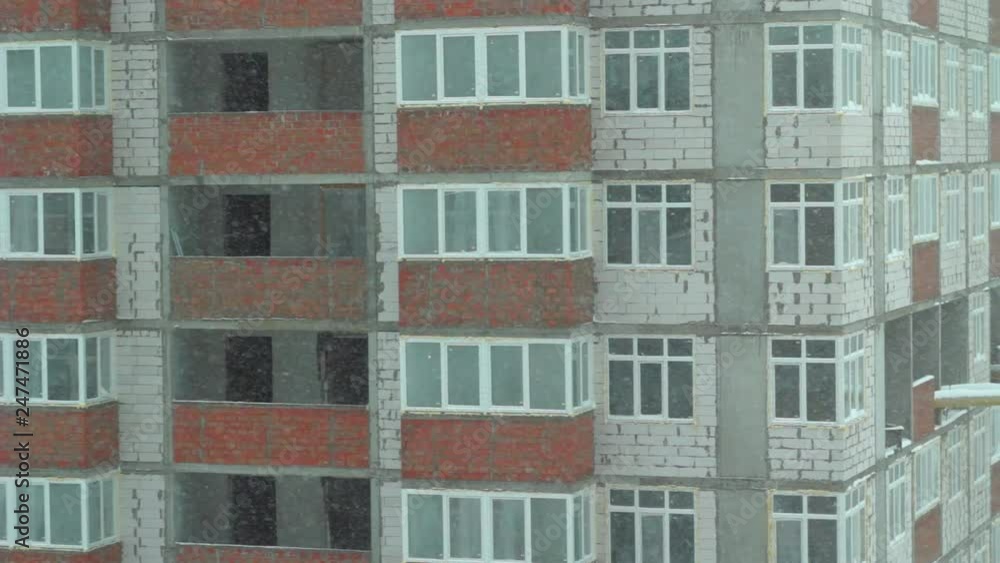 Snowing in city with view to apartment house under construction. Close up snowy storm in city Snowing in city with view to apartment house under construction. Close up snowy storm in city