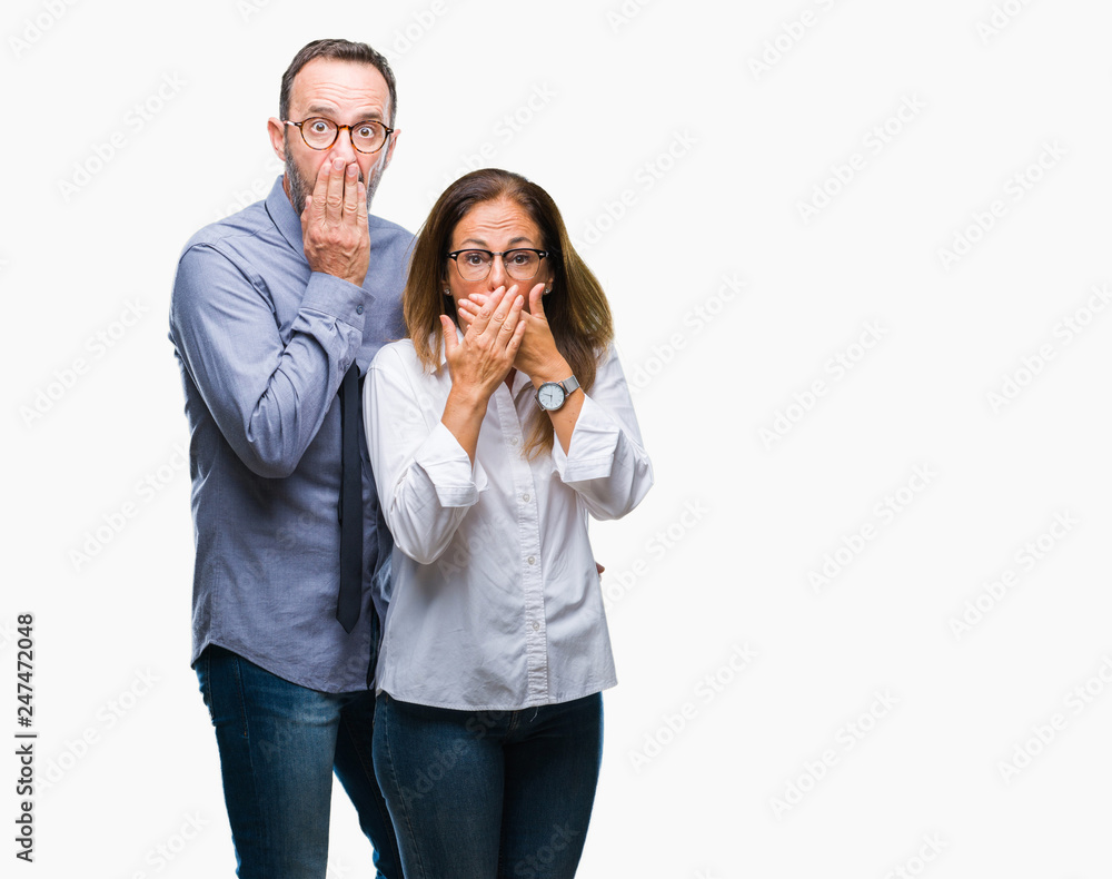 Middle age hispanic couple in love wearing glasses over isolated background shocked covering mouth with hands for mistake. Secret concept.