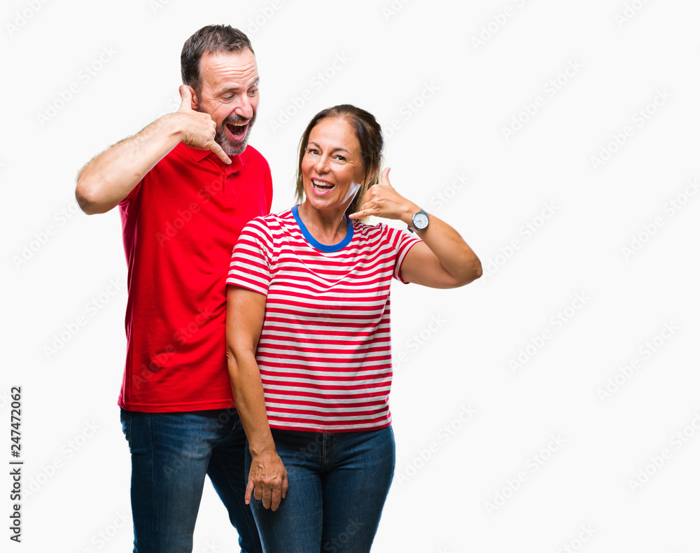 Middle age hispanic couple in love over isolated background smiling doing phone gesture with hand and fingers like talking on the telephone. Communicating concepts. Middle age hispanic couple in love over isolated background smiling doing phone gesture with hand and fingers like talking on the telephone. Communicating concepts.