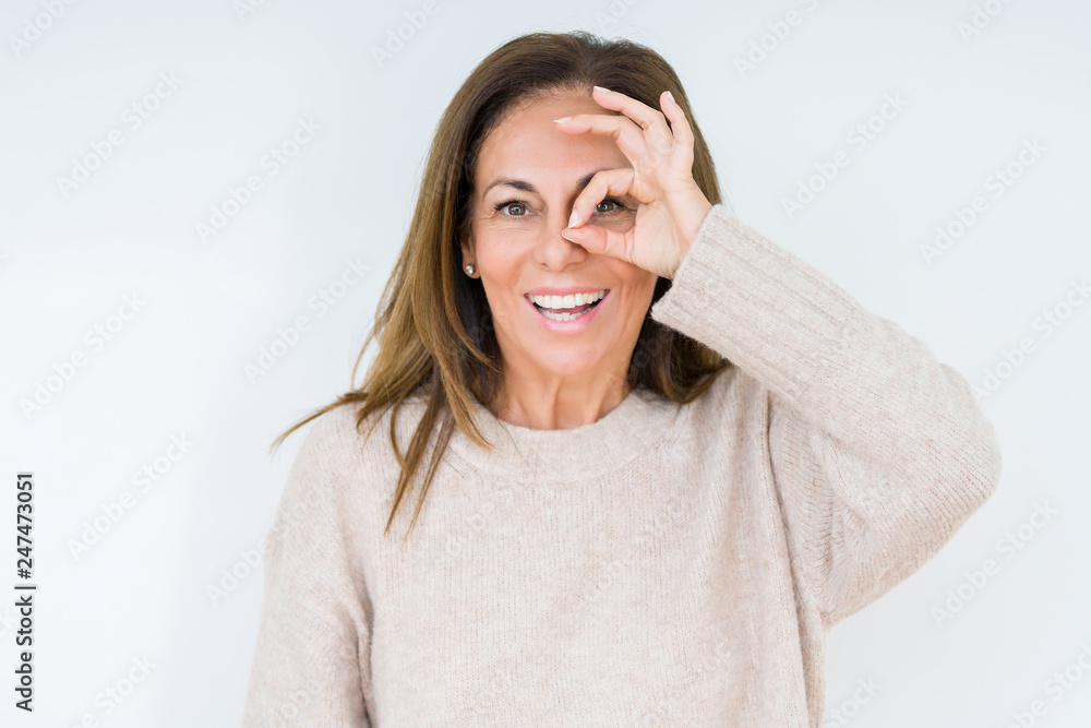 Beautiful middle age woman over isolated background doing ok gesture with hand smiling, eye looking through fingers with happy face. Beautiful middle age woman over isolated background doing ok gesture with hand smiling, eye looking through fingers with happy face.