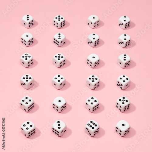 Square gaming dice pattern on pink background in flat lay style