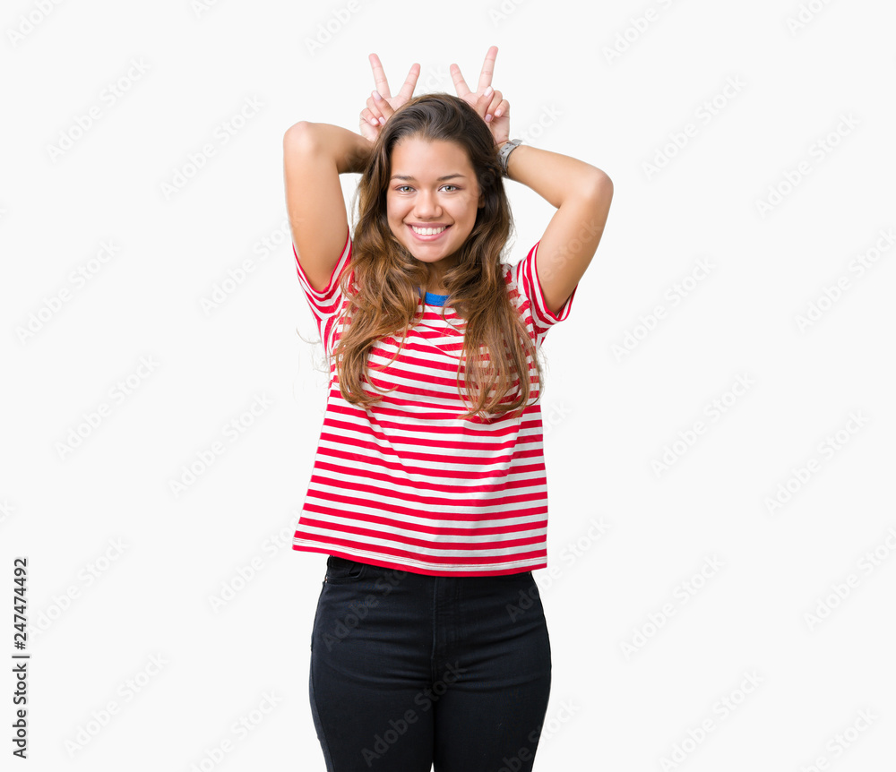 Young beautiful brunette woman wearing stripes t-shirt over isolated background Posing funny and crazy with fingers on head as bunny ears, smiling cheerful Young beautiful brunette woman wearing stripes t-shirt over isolated background Posing funny and crazy with fingers on head as bunny ears, smiling cheerful