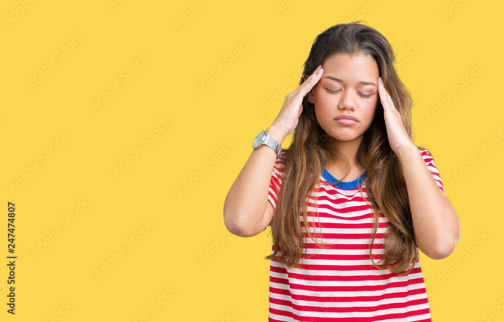 Young beautiful brunette woman wearing stripes t-shirt over isolated background with hand on head for pain in head because stress. Suffering migraine. Young beautiful brunette woman wearing stripes t-shirt over isolated background with hand on head for pain in head because stress. Suffering migraine.