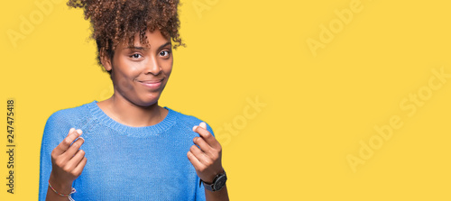 Beautiful young african american woman over isolated background Doing money gesture with hand, asking for salary payment, millionaire business photo