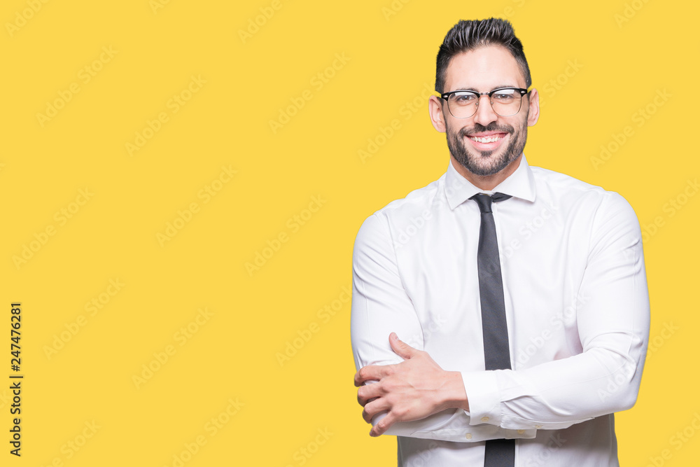 Young handsome business man wearing glasses over isolated background happy face smiling with crossed arms looking at the camera. Positive person.