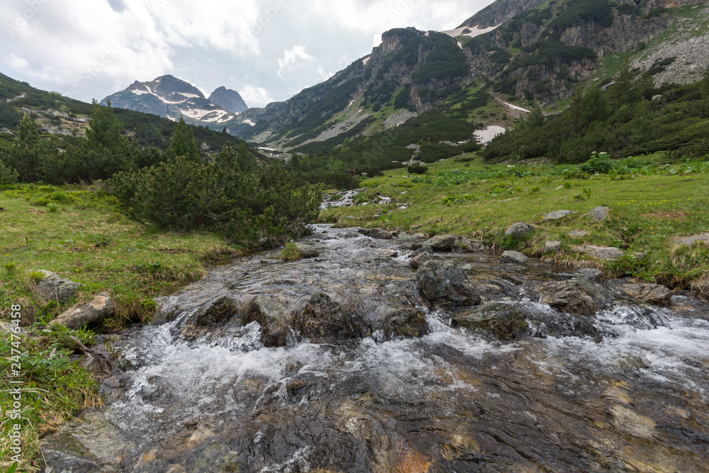 Landscape with dark clouds over Malyovitsa peak and Malyoviska river, Rila Mountain, Bulgaria