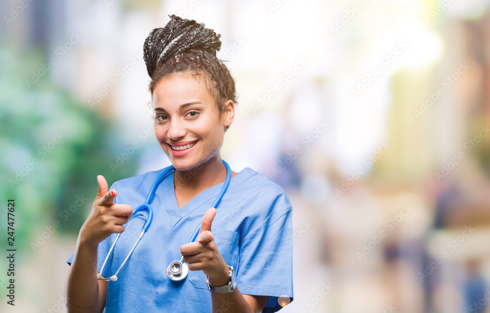 Φωτογραφία Young braided hair african american girl professional surgeon over isolated background pointing fingers to camera with happy and funny face