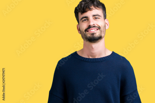 Young handsome man over isolated background Hands together and fingers crossed smiling relaxed and cheerful. Success and optimistic