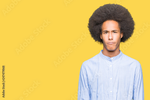 Young african american man with afro hair skeptic and nervous, frowning upset because of problem. Negative person.