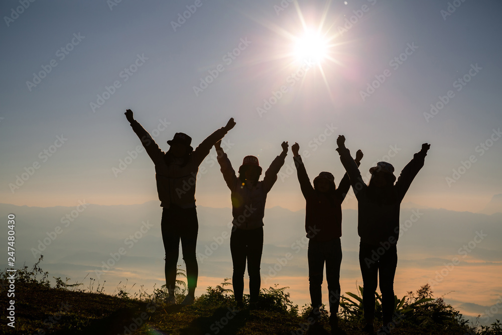 Silhouette group of young woman having fun outdoors; sunrise