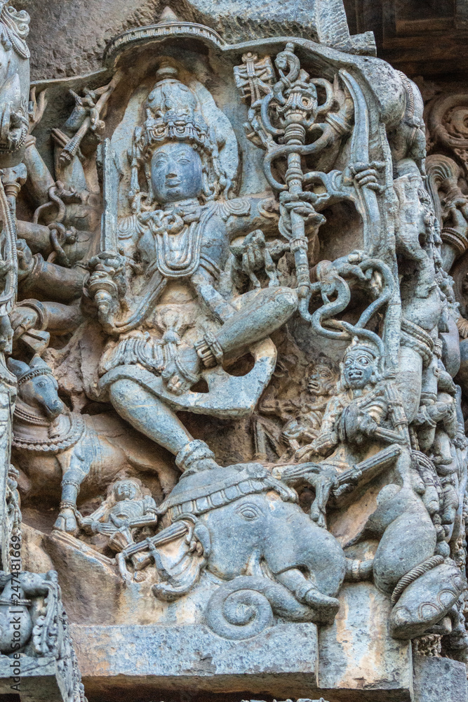 Halebidu, Karnataka, India - November 2, 2013: Hoysaleswara Temple of Shiva. Statue on side of main sanctuary, where Lord Shiva as Gajasurasamhara, killer of elephant demon, dances on head of animal.