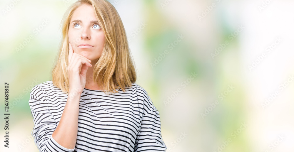 Beautiful young woman wearing stripes sweater over isolated background with hand on chin thinking about question, pensive expression. Smiling with thoughtful face. Doubt concept. Beautiful young woman wearing stripes sweater over isolated background with hand on chin thinking about question, pensive expression. Smiling with thoughtful face. Doubt concept.