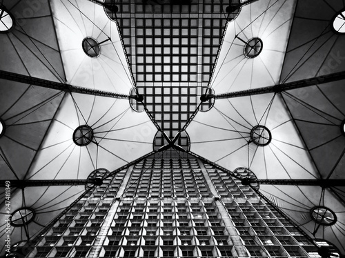 Architectural construction with symmetrical shapes, in La Defence, Paris. looking up