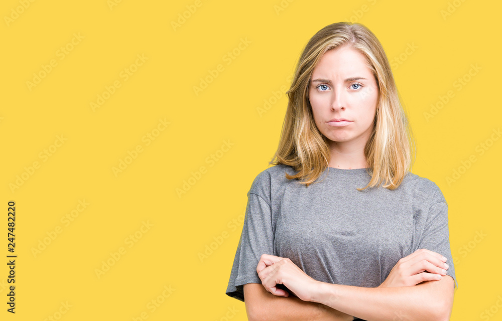 Beautiful young woman wearing oversize casual t-shirt over isolated background skeptic and nervous, disapproving expression on face with crossed arms. Negative person. Beautiful young woman wearing oversize casual t-shirt over isolated background skeptic and nervous, disapproving expression on face with crossed arms. Negative person.