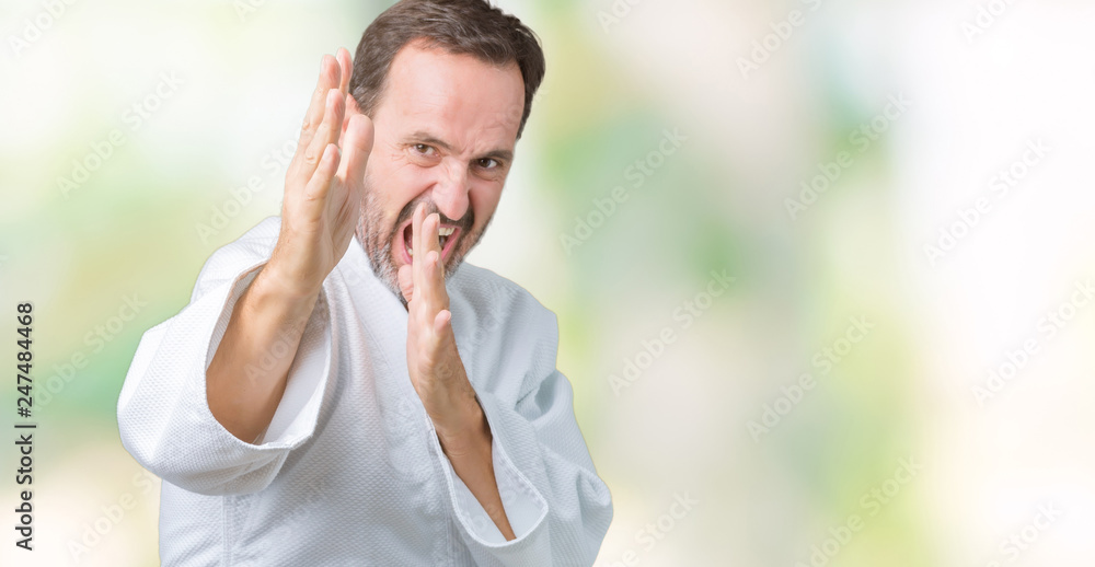 Handsome middle age senior man wearing kimono uniform over isolated background Ready to fight with fist defense gesture, angry and upset face, afraid of problem Handsome middle age senior man wearing kimono uniform over isolated background Ready to fight with fist defense gesture, angry and upset face, afraid of problem