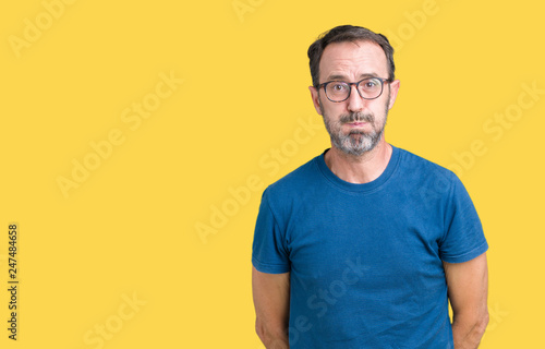 Handsome middle age hoary senior man wearin glasses over isolated background puffing cheeks with funny face. Mouth inflated with air, crazy expression.