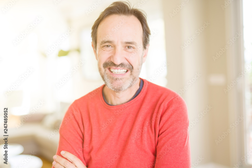 Handsome middle age man smiling looking at the camera at home Handsome middle age man smiling looking at the camera at home