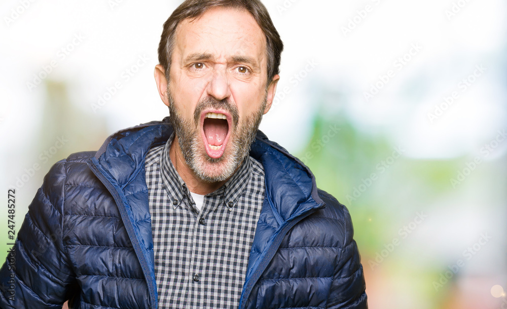 Fototapeta premium Middle age handsome man wearing winter coat In shock face, looking skeptical and sarcastic, surprised with open mouth