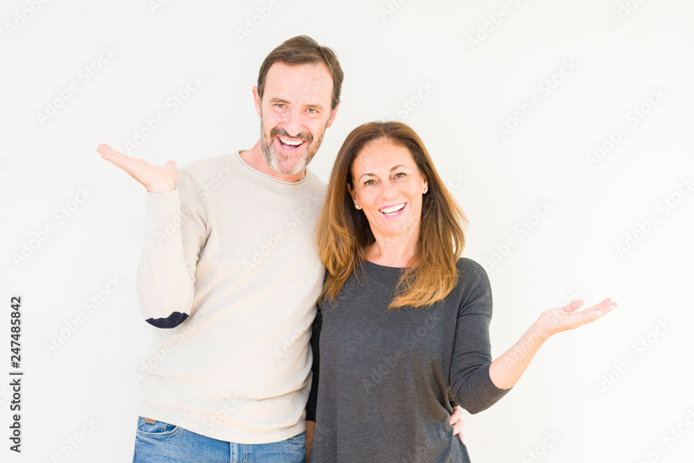 Beautiful middle age couple in love over isolated background Smiling showing both hands open palms, presenting and advertising comparison and balance Beautiful middle age couple in love over isolated background Smiling showing both hands open palms, presenting and advertising comparison and balance