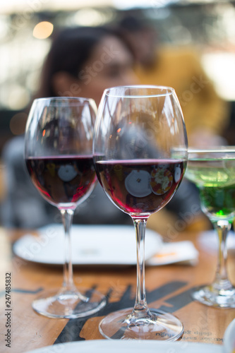 red wine glasses infront of young adult couple