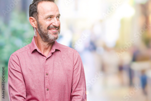 Middle age hoary senior man over isolated background looking away to side with smile on face, natural expression. Laughing confident.
