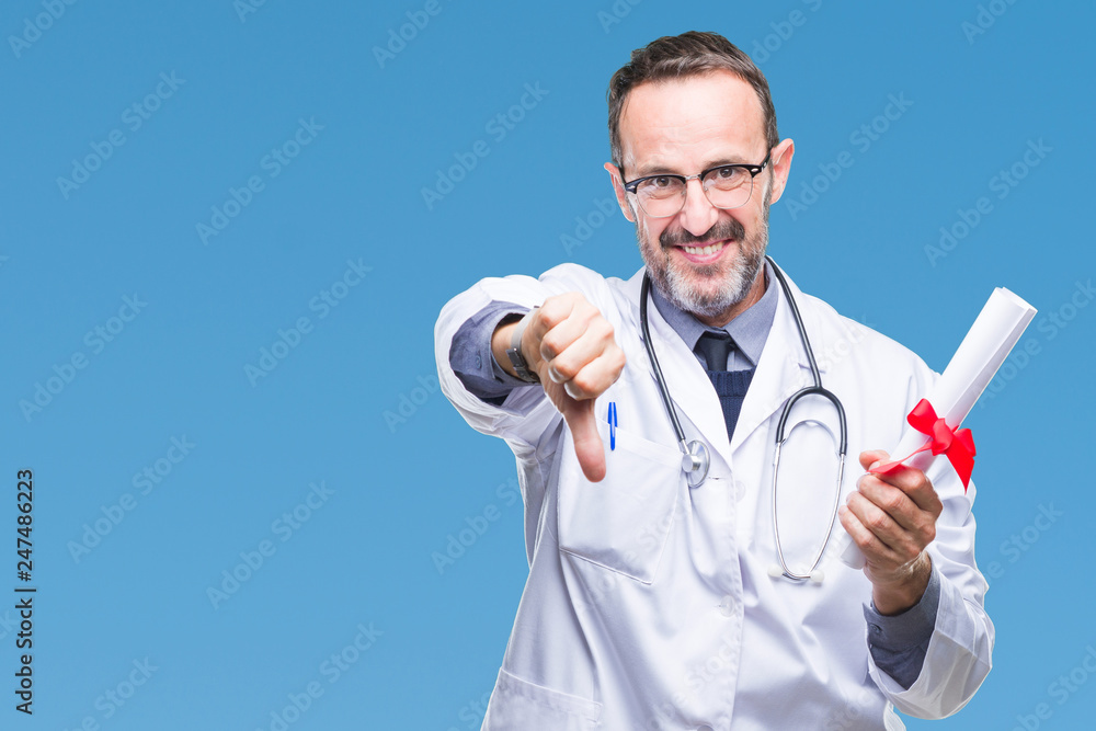 Middle age senior hoary doctor man holding degree certificate over isolated background with angry face, negative sign showing dislike with thumbs down, rejection concept Middle age senior hoary doctor man holding degree certificate over isolated background with angry face, negative sign showing dislike with thumbs down, rejection concept