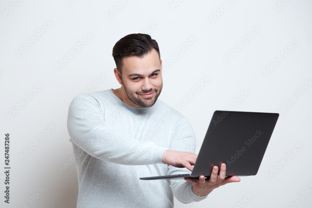 Portrait of young man typing on laptop keyboard over white background. Portrait of young man typing on laptop keyboard over white background.