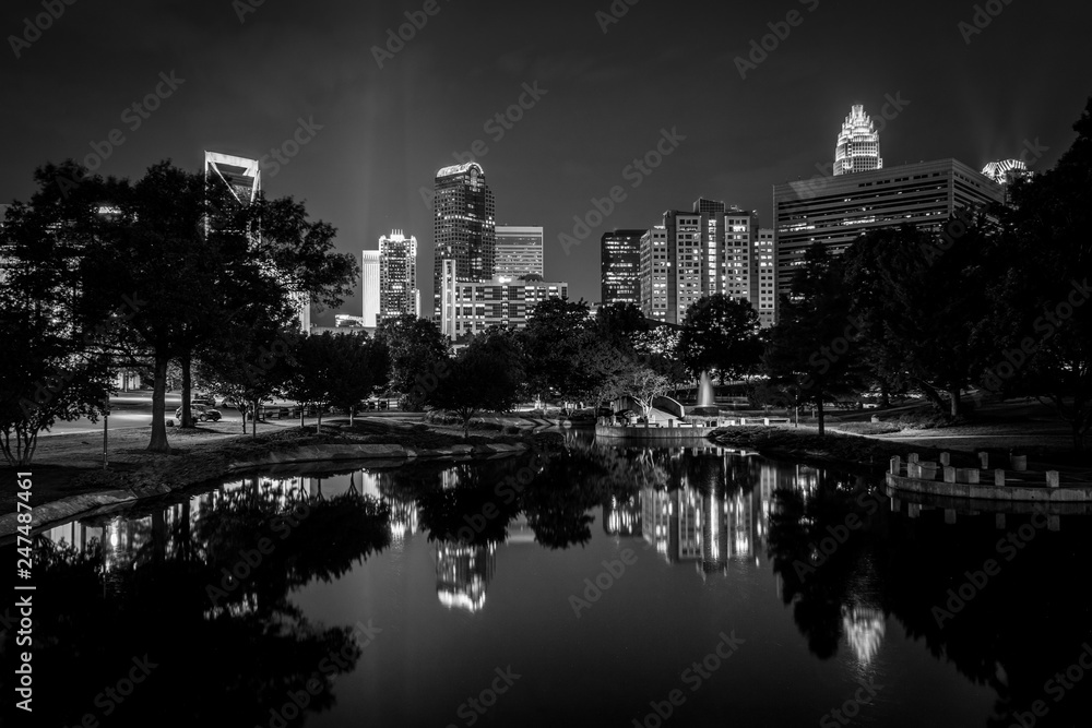 The Uptown skyline and a lake at Marshall Park at night, in Charlotte, North Carolina.