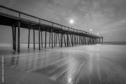 Waves in the Atlantic Ocean and the fishing pier at twilight, in Ocean City, Maryland.