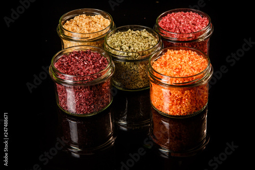 small glass jars filled with different colors sea salt