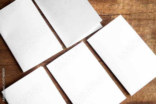 Blank portrait mock-up paper. brochure magazine isolated on brown wooden table, changeable background / white paper isolated on wood