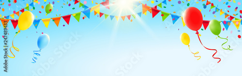 Bunte Girlanden, Luftballons und Konfetti vor sonnigem Himmel