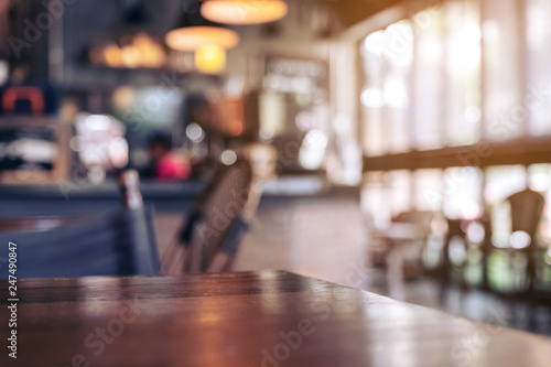 Murais de parede Wooden table with blurred background in cafe