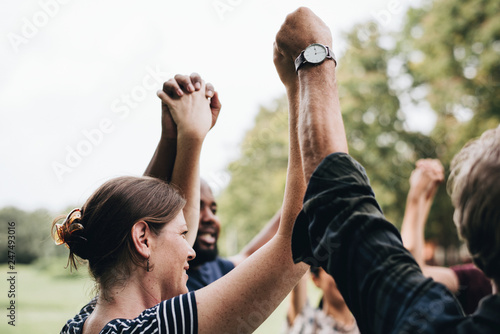 Happy diverse people holding hands in the park photo