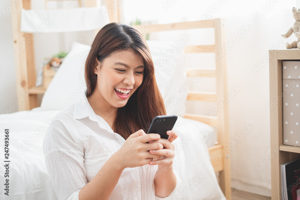 Beautiful Asian woman using laptop and smart phone in bed room for online shopping, Asian woman lifestyle concept Beautiful Asian woman using laptop and smart phone in bed room for online shopping, Asian woman lifestyle concept