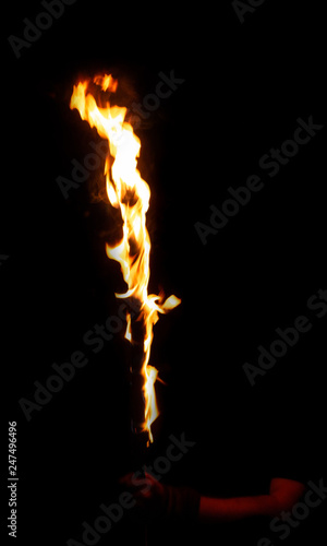 Burning fire stick in mans arm, cane in flame isolated on black