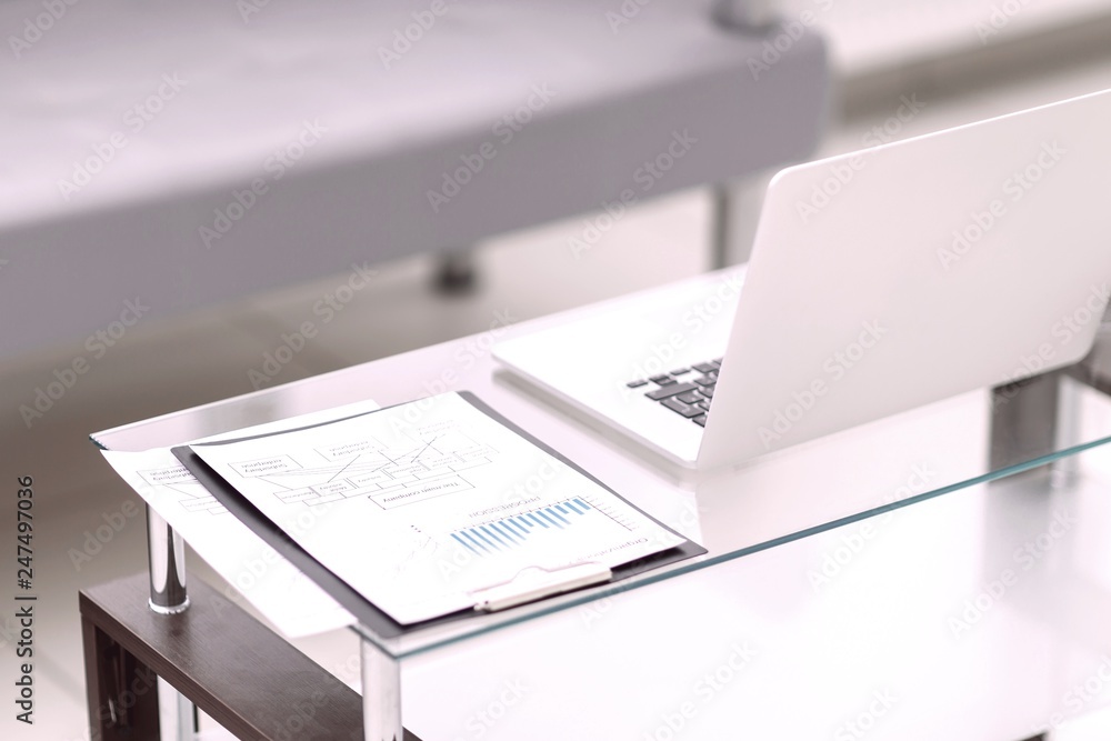 laptop and financial charts, pen lying on the document laptop and financial charts, pen lying on the document
